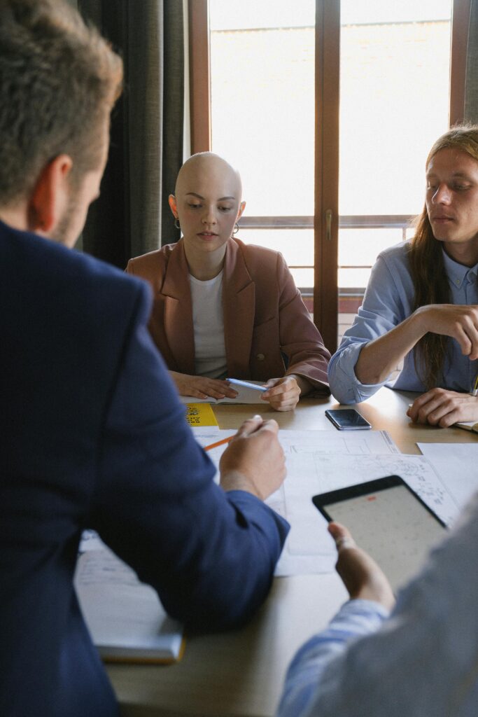 Businesspeople speaking while using tablet and analyzing information during conference in business office in daytime